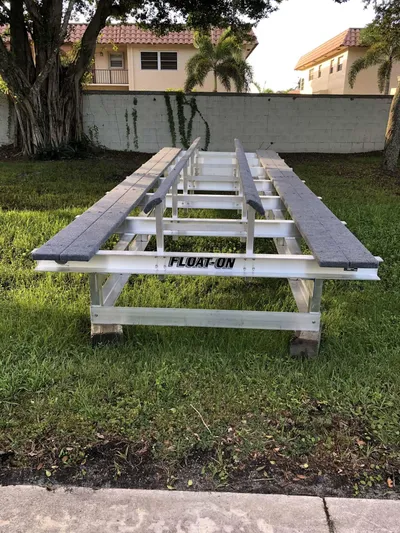  Yacht Photos Pics Boat trailer frame on grass, labeled "FLOAT-ON," near residential area. Tideline 365, 2020 model.