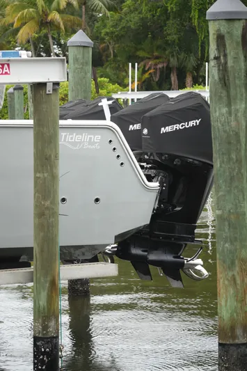  Yacht Photos Pics Tideline 365 boat with Mercury engines docked, surrounded by lush greenery.