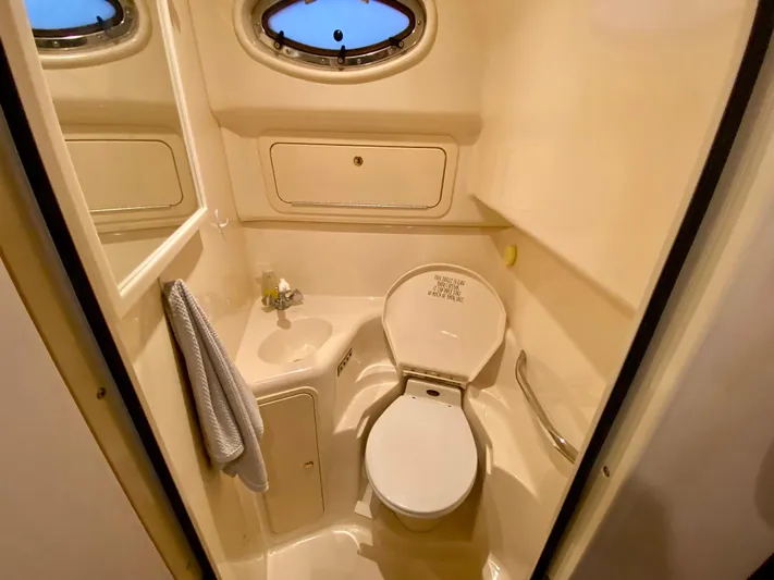  Yacht Photos Pics 1999 Sea Ray 400 Sundancer bathroom with toilet, sink, and porthole window.