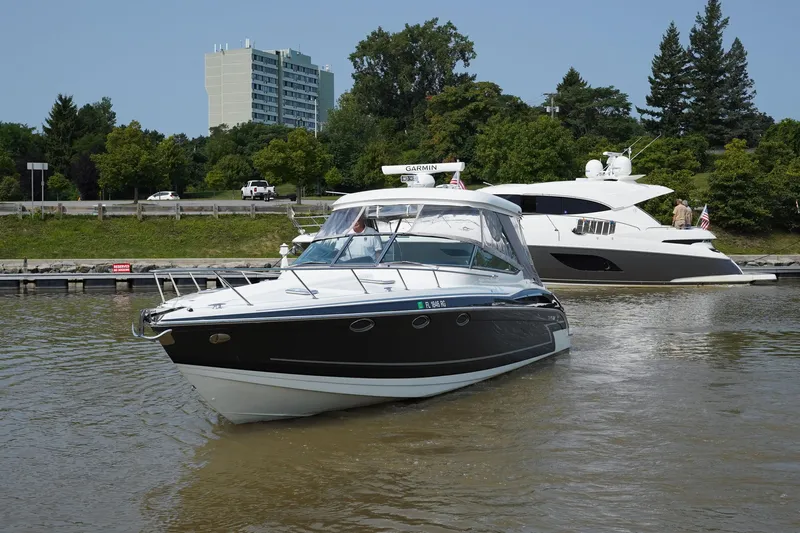 Have A Nice Life Yacht Photos Pics 2017 Formula 370 Super Sport boat docked on a calm river with trees and buildings in the background.
