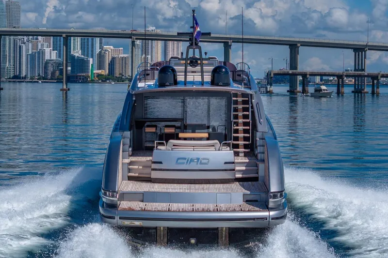 Ciao Yacht Photos Pics 2025 Pershing GTX 80 yacht cruising near a city skyline and bridge.