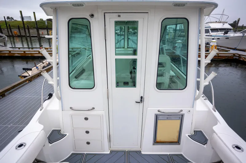 Boston Whaler 285 Yacht Photos Pics 2013 Boston Whaler 285 Conquest Pilothouse, rear view at dock, showcasing cabin entrance.