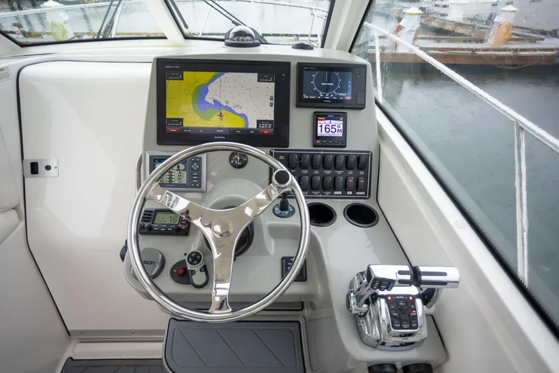 Boston Whaler 285 Yacht Photos Pics Pilothouse of 2013 Boston Whaler 285 Conquest with navigation equipment and steering wheel.