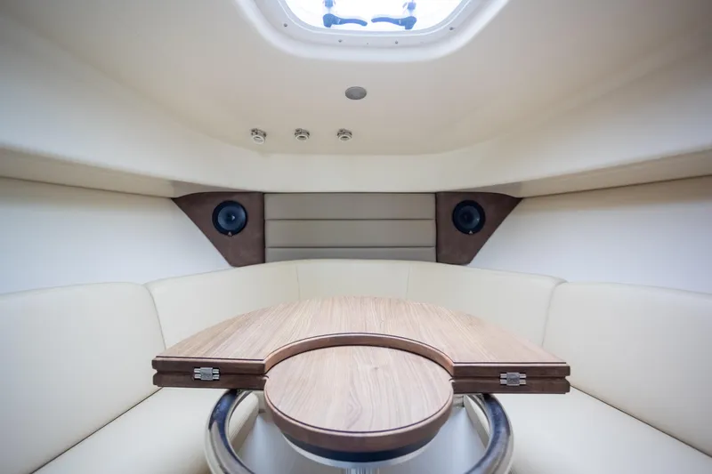 Boston Whaler 285 Yacht Photos Pics Interior of 2013 Boston Whaler 285 Conquest Pilothouse with wooden table and cushioned seating.