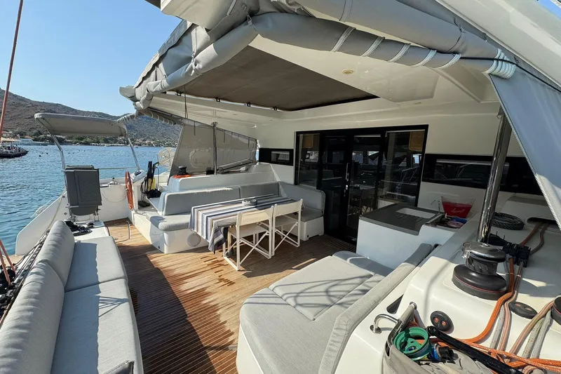  Yacht Photos Pics Luxurious 2021 Excess 15 yacht deck with seating and dining area, docked by scenic waters.