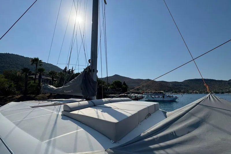  Yacht Photos Pics Sailing yacht Excess 15, 2021 model, docked in a scenic coastal area under clear skies.