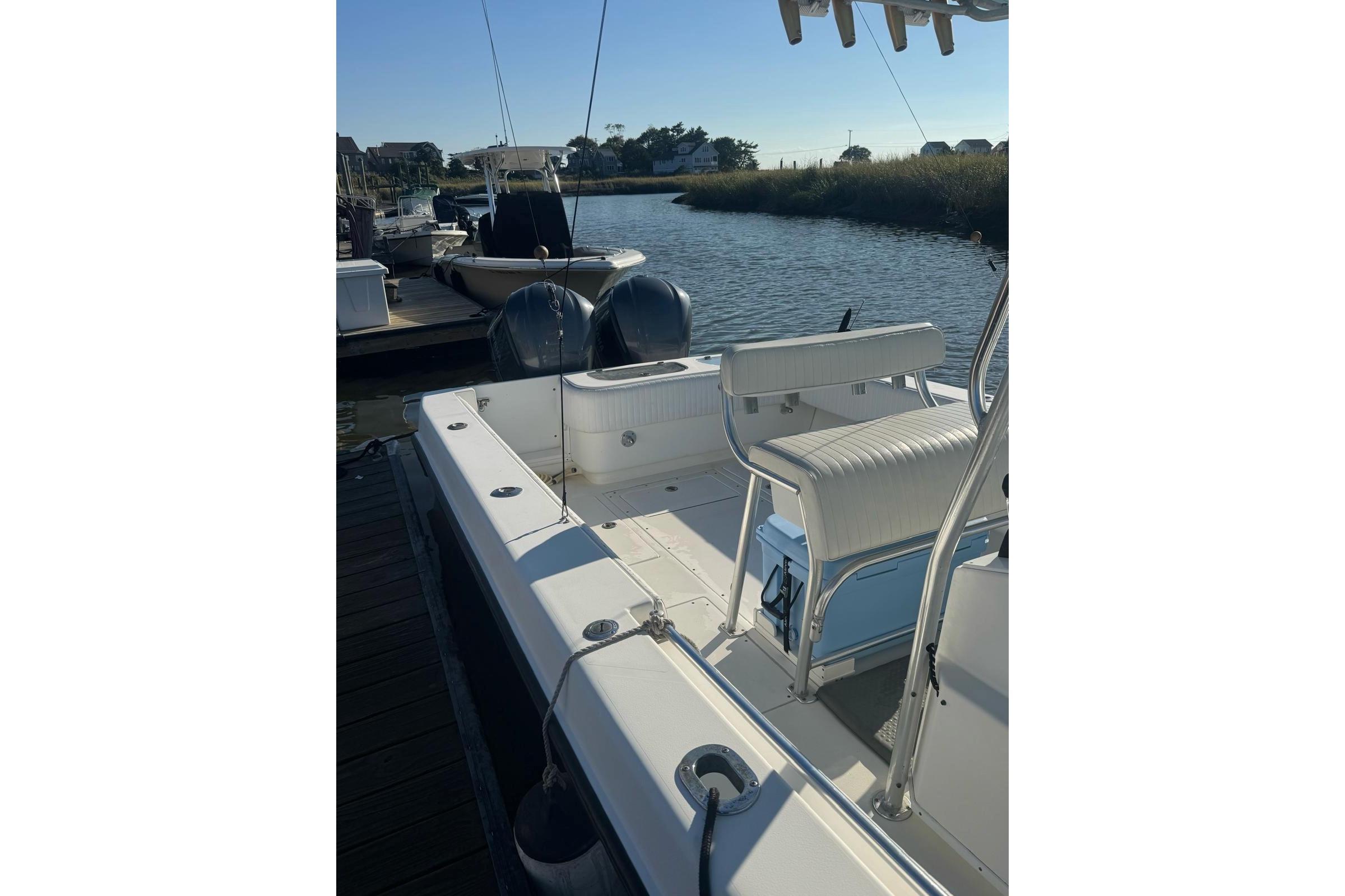 2001 Contender 31 Open boat docked by a serene waterfront.