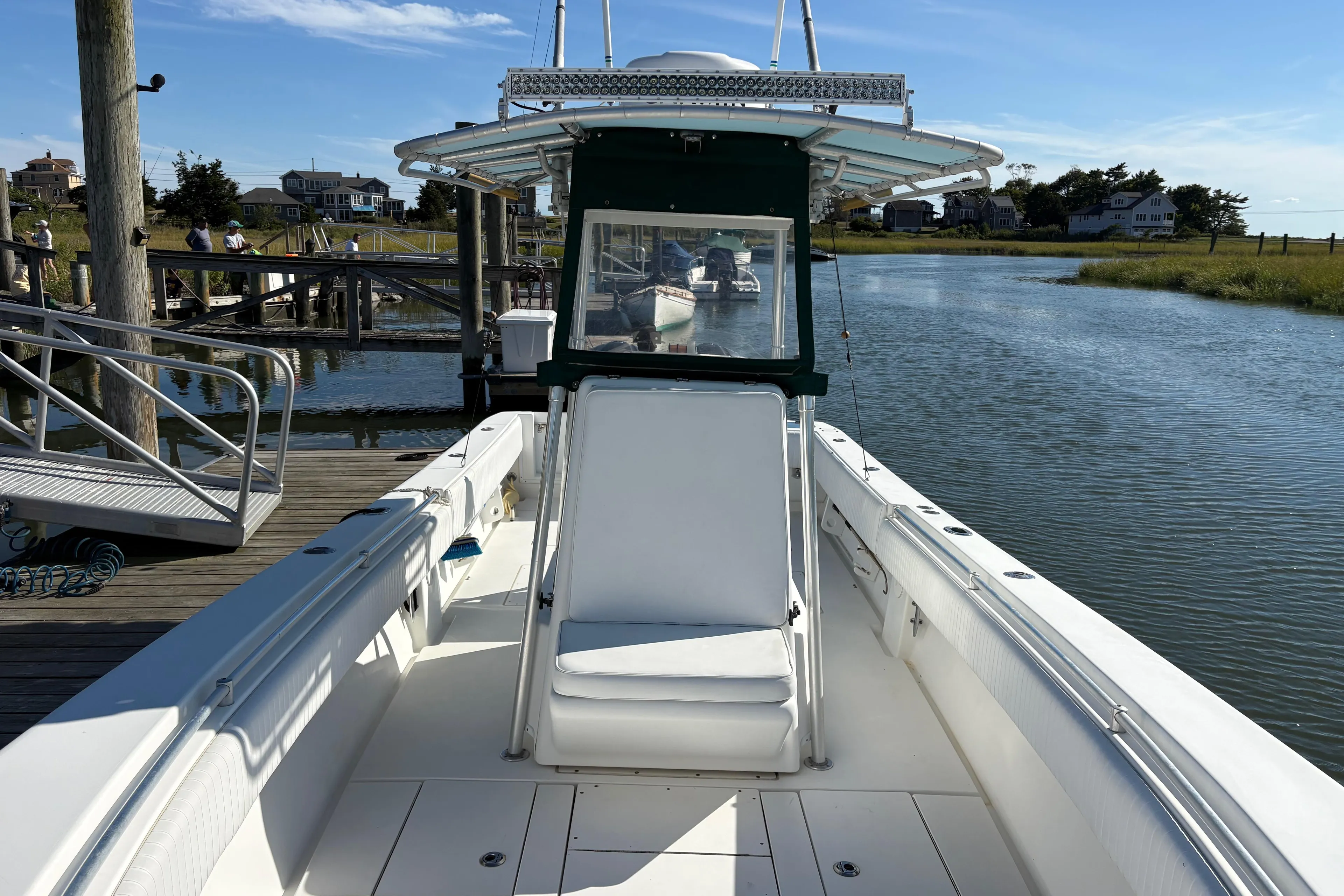 2001 Contender 31 Open boat docked by a serene waterfront on a sunny day.