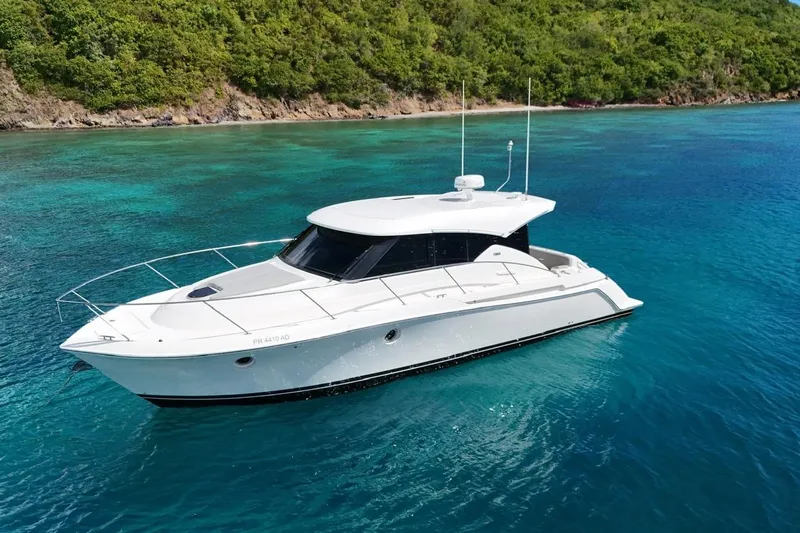  Yacht Photos Pics 2022 Tiara Yachts C39 Coupe on clear blue water near lush green shoreline.