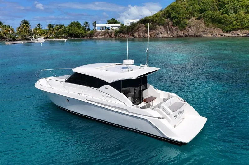  Yacht Photos Pics 2022 Tiara Yachts C39 Coupe in tropical waters, surrounded by lush greenery.