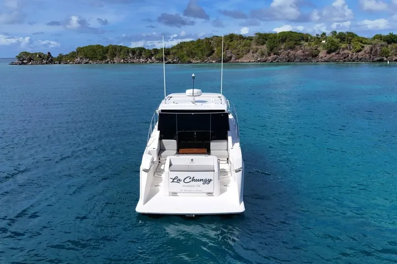  Yacht Photos Pics 2022 Tiara Yachts C39 Coupe on clear blue water near lush island.