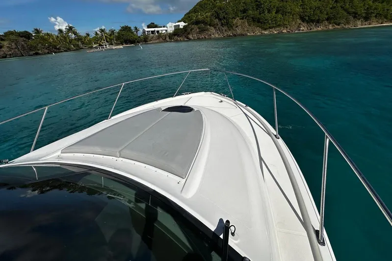  Yacht Photos Pics 2022 Tiara Yachts C39 Coupe cruising in clear blue waters near a tropical island.