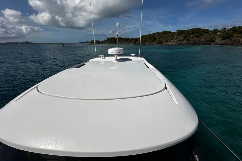  Yacht Photos Pics 2022 Tiara Yachts C39 Coupe cruising in clear blue waters under a partly cloudy sky.