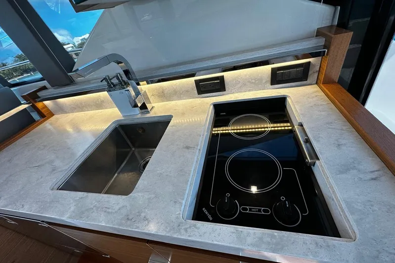  Yacht Photos Pics Modern kitchen area in 2022 Tiara Yachts C39 Coupe with sink and electric stove.