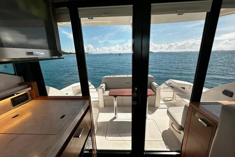  Yacht Photos Pics Interior view of 2022 Tiara Yachts C39 Coupe overlooking ocean through glass doors.