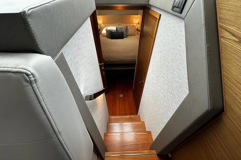  Yacht Photos Pics Interior view of 2022 Tiara Yachts C39 Coupe, featuring elegant wooden stairs and cozy bedroom.