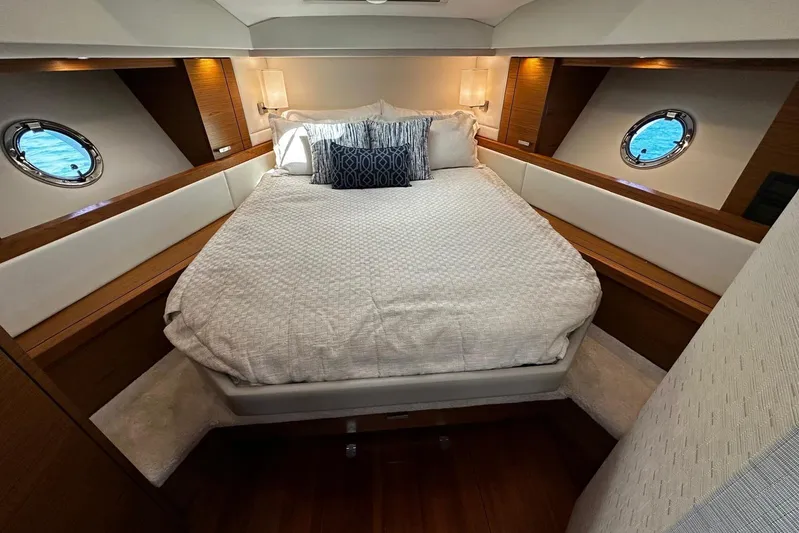  Yacht Photos Pics Luxurious bedroom interior of 2022 Tiara Yachts C39 Coupe with elegant bedding and porthole windows.