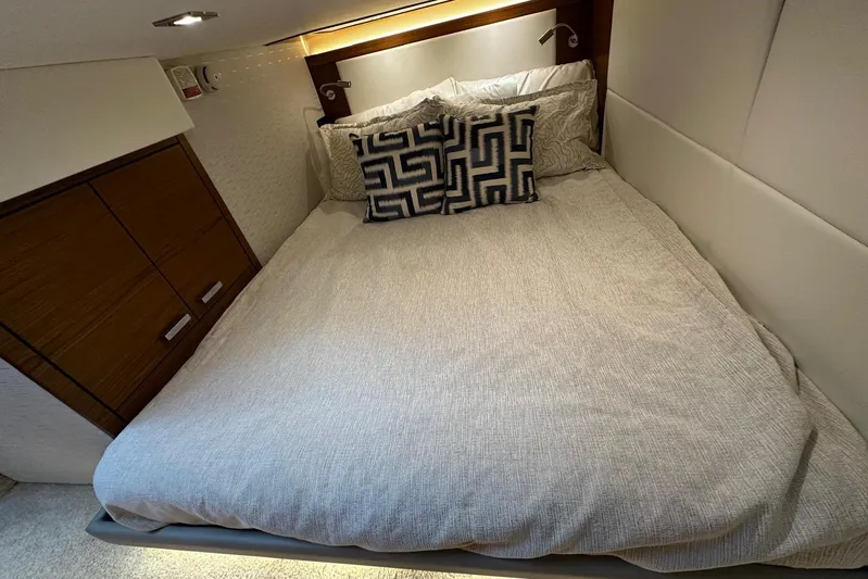  Yacht Photos Pics Luxurious bedroom interior of 2022 Tiara Yachts C39 Coupe with modern bedding and wood accents.