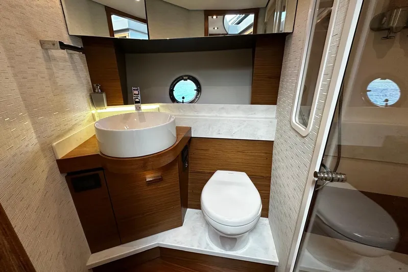  Yacht Photos Pics Luxurious bathroom in 2022 Tiara Yachts C39 Coupe with modern fixtures and porthole view.