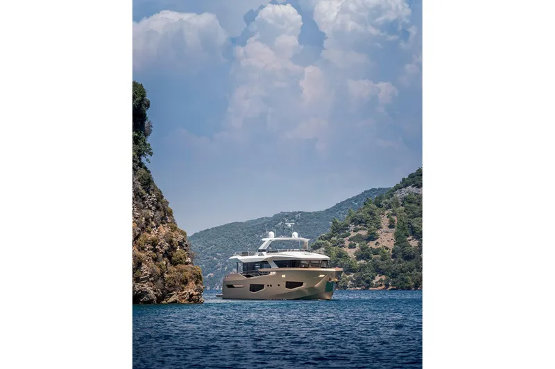 Numarine 26xp Yacht Photos Pics 2025 Numarine 26XP yacht cruising between scenic cliffs and lush greenery.