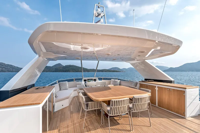 Numarine 26xp Yacht Photos Pics Luxurious 2025 Numarine 26XP yacht deck with dining area, overlooking serene ocean and mountains.