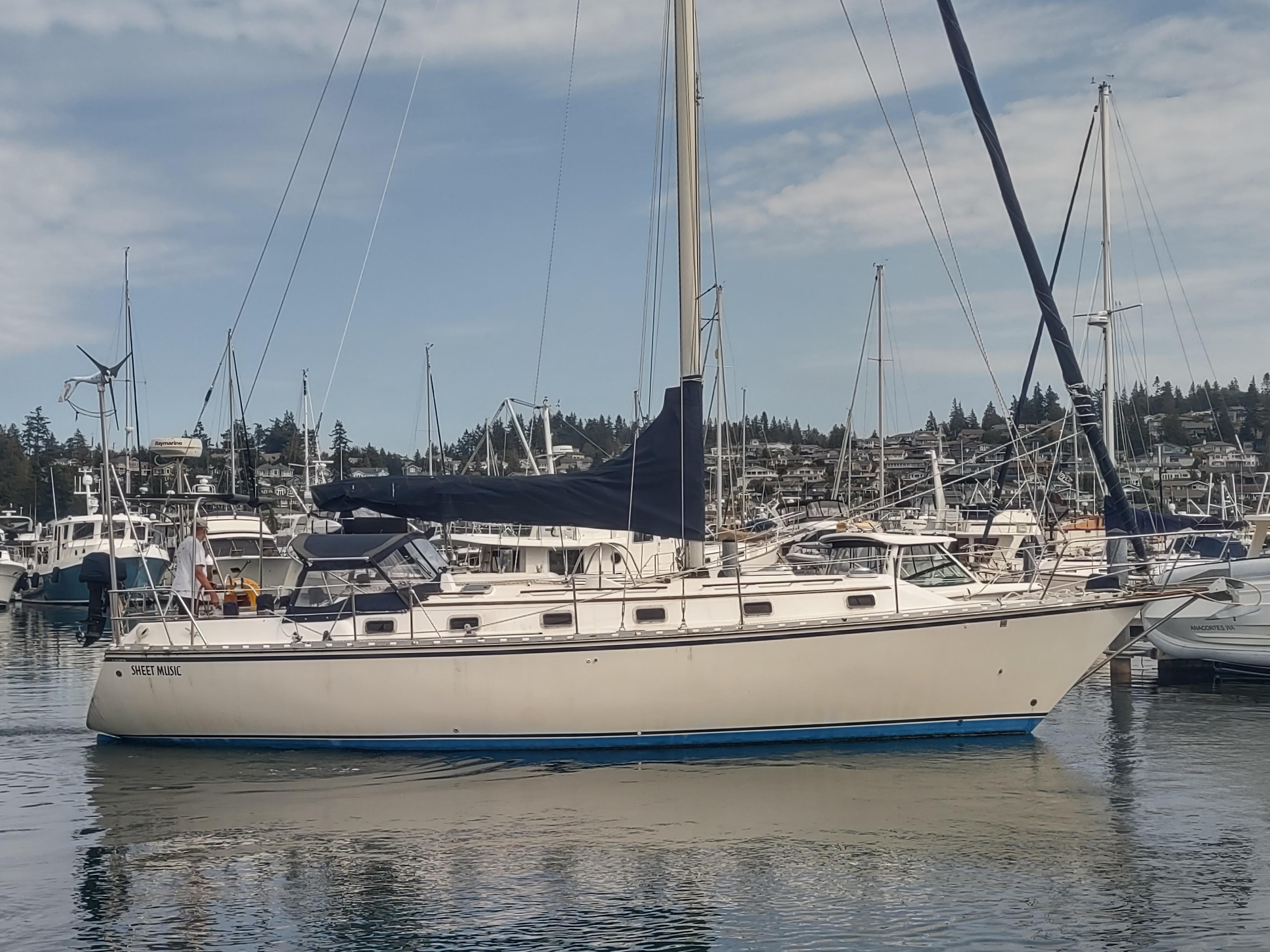 1989 Caliber 38 sailboat docked in a marina with other boats.