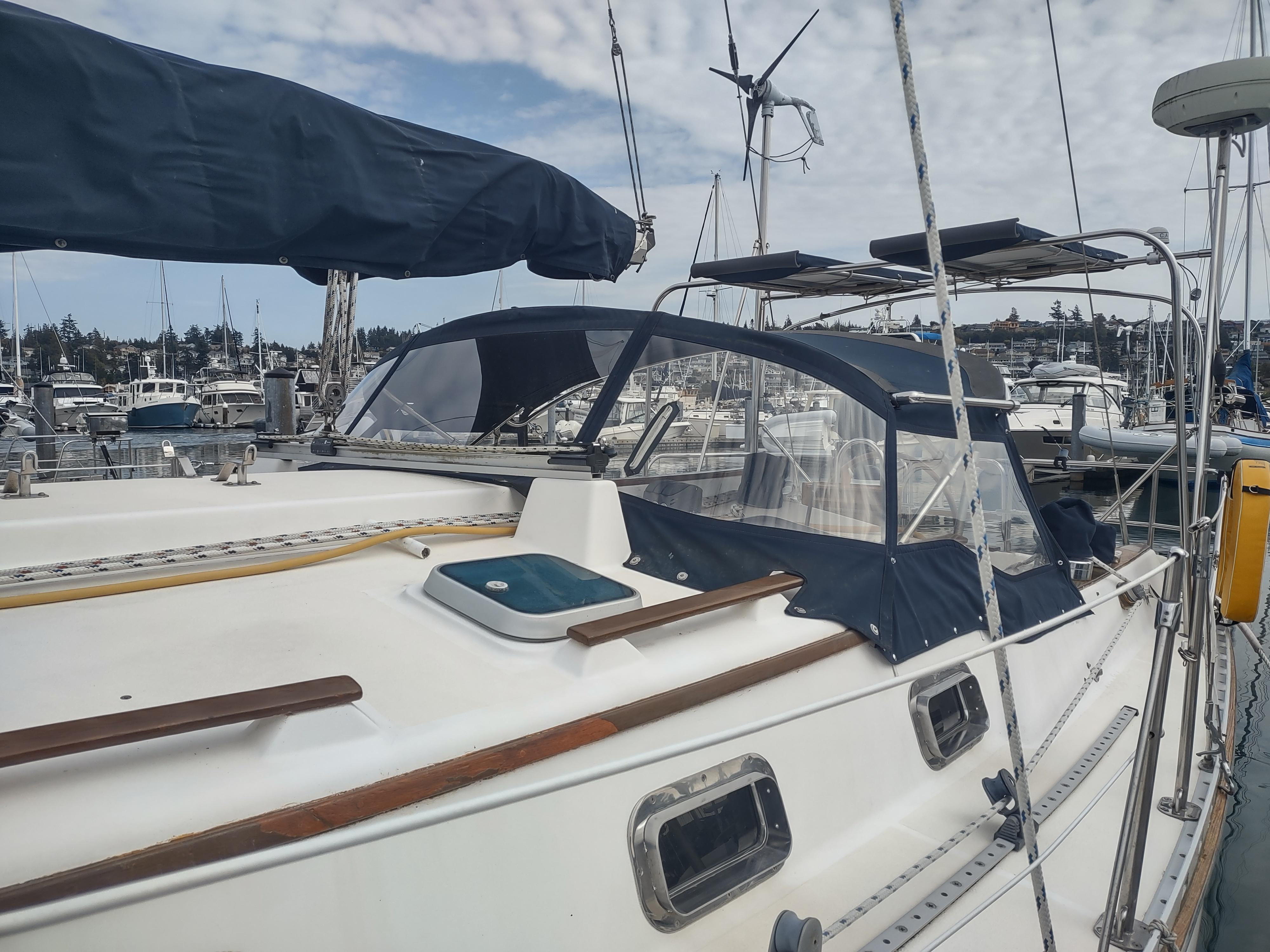 1989 Caliber 38 sailboat docked at a marina with blue canvas covers.