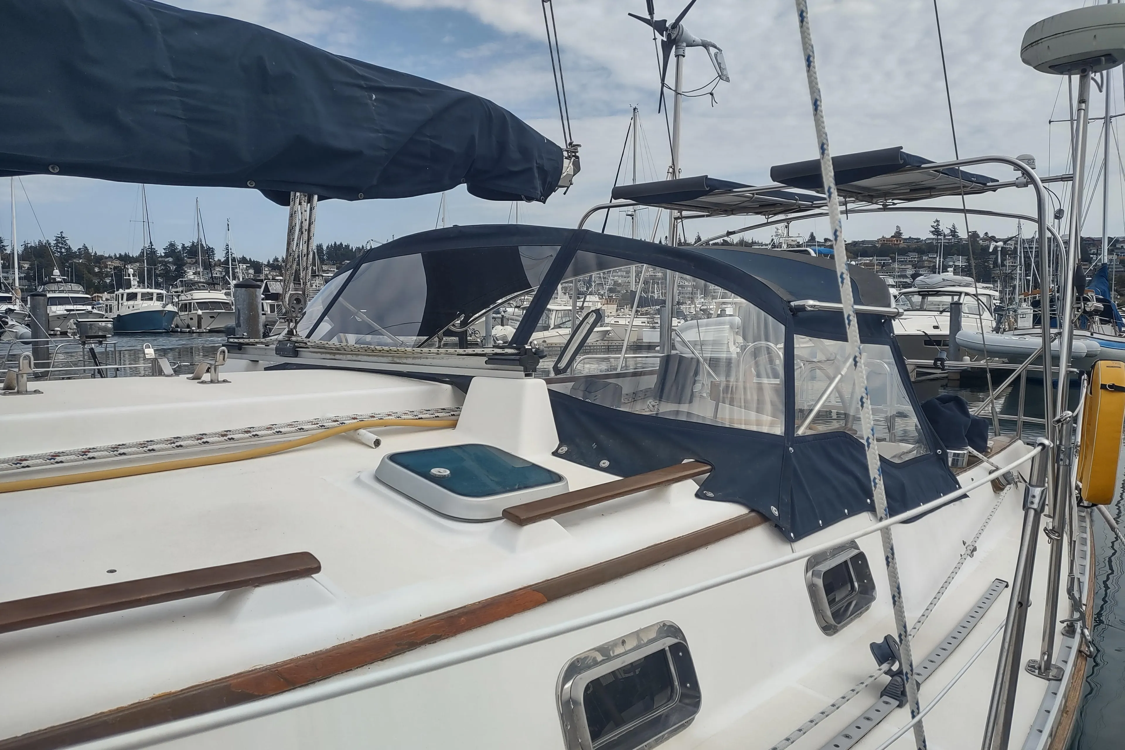 1989 Caliber 38 sailboat docked at a marina with blue canvas covers.