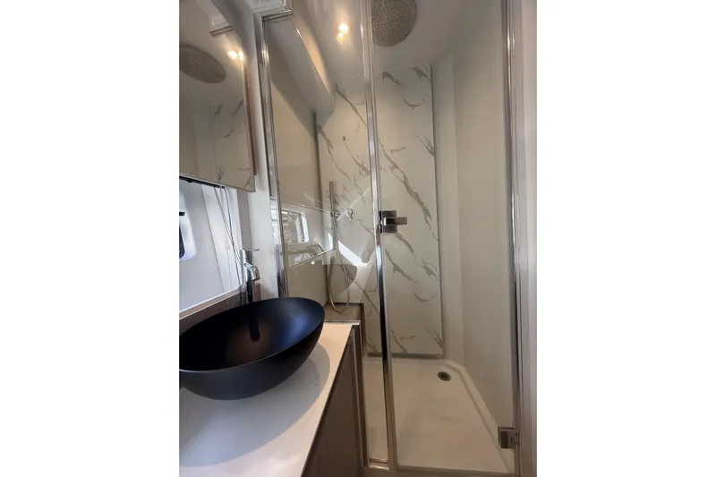  Yacht Photos Pics Luxurious bathroom in 2024 Azimut 53 Fly yacht with modern shower and sleek black basin.