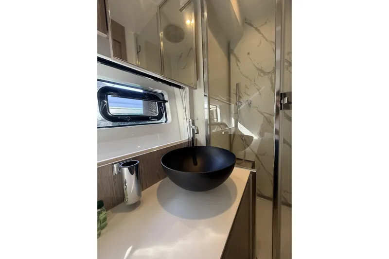  Yacht Photos Pics Luxurious bathroom in 2024 Azimut 53 Fly yacht with modern black basin and marble accents.