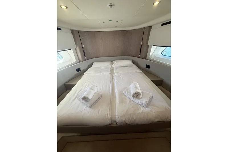  Yacht Photos Pics Luxurious bedroom interior of 2024 Azimut 53 Fly yacht with neatly arranged bed and towels.