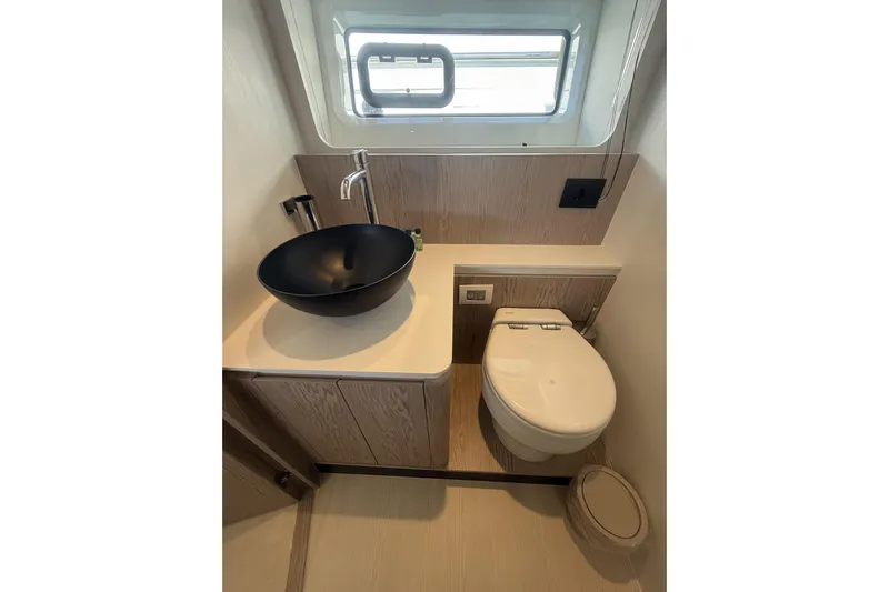  Yacht Photos Pics Modern bathroom in 2024 Azimut 53 Fly yacht with sleek black sink and compact toilet.