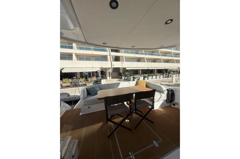  Yacht Photos Pics Luxurious 2024 Azimut 53 Fly yacht deck with seating and table, docked at marina.