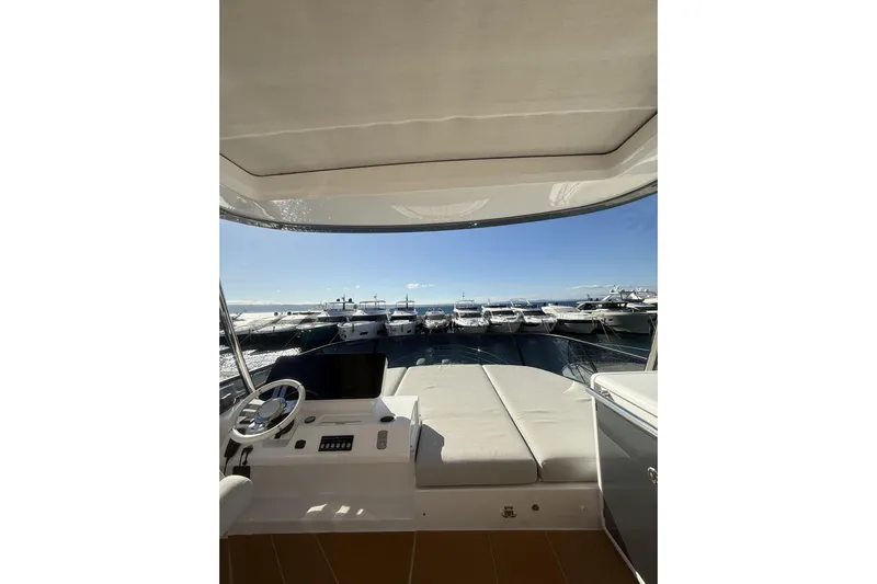  Yacht Photos Pics 2024 Azimut 53 Fly yacht interior with helm and sunbed, overlooking marina.