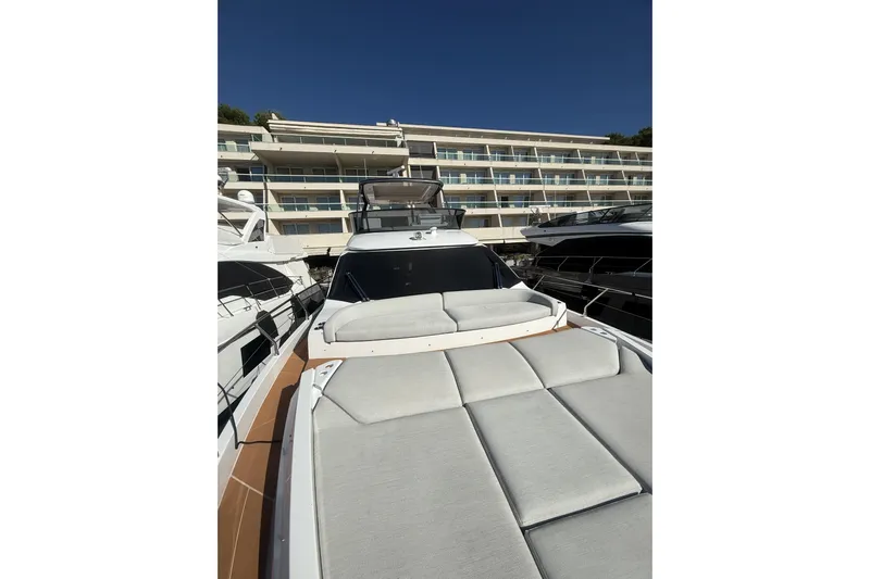  Yacht Photos Pics 2024 Azimut 53 Fly yacht with sunbathing area, docked near modern building.