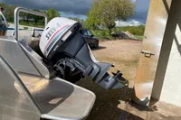 Boat with Selva outboard motor, Evens Defender 2022, parked outdoors on a sunny day.