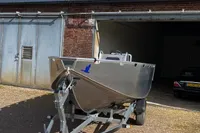 2022 Evens Defender boat on trailer outside a garage.