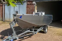 2022 Evens Defender boat on trailer outside a brick building.