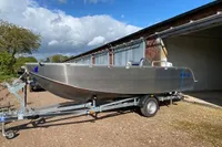 2022 Evens Defender boat on trailer, parked outdoors near a building.