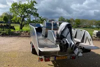 2022 Evens Defender boat with outboard motor on a trailer, parked outdoors.