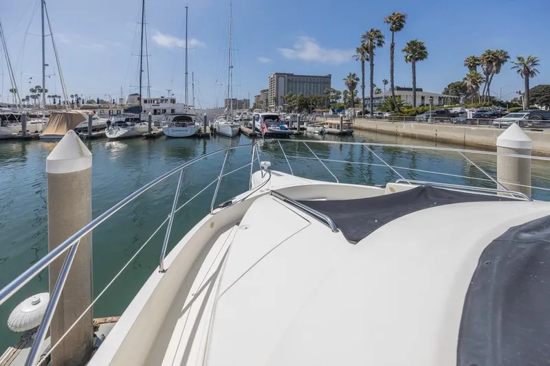 Just Joyce Yacht Photos Pics Bow view of 2000 Silverton 435 yacht docked in a marina with palm trees.