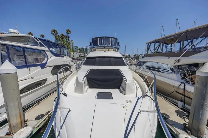 Just Joyce Yacht Photos Pics 2000 Silverton 435 yacht docked at marina, surrounded by other boats under clear blue sky.