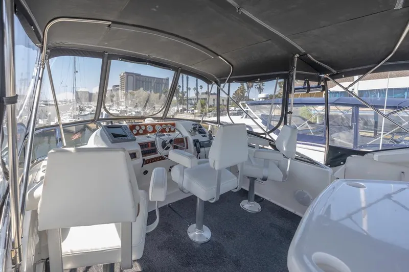 Just Joyce Yacht Photos Pics Interior view of 2000 Silverton 435 yacht cockpit with white seating and control panel.