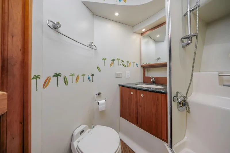 Just Joyce Yacht Photos Pics Bathroom interior of 2000 Silverton 435 yacht with surfboard and palm tree decor.