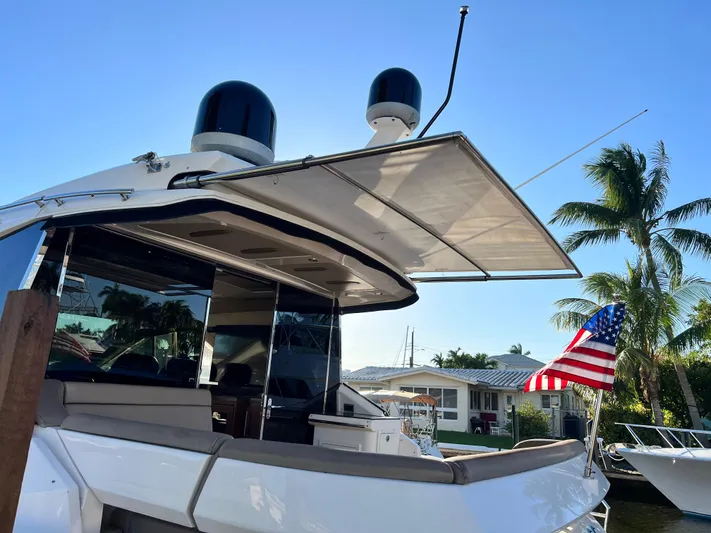 Day Off Yacht Photos Pics 2015 Regal 53 Sport Coupe yacht docked, featuring sleek design and American flag, under clear blue sky.