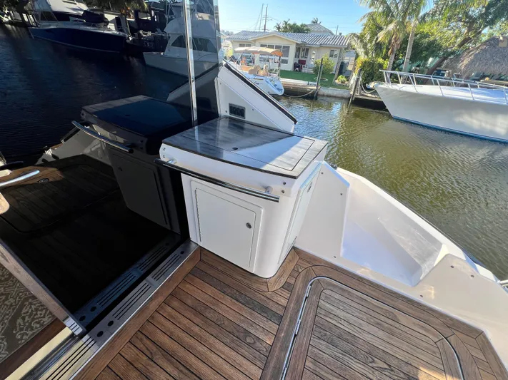 Day Off Yacht Photos Pics 2015 Regal 53 Sport Coupe yacht deck with wood flooring and outdoor kitchen area.