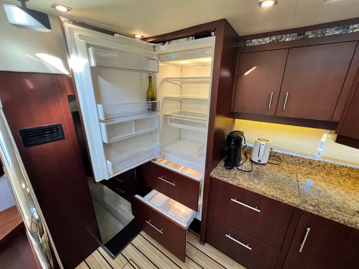 Day Off Yacht Photos Pics Luxurious kitchen interior of 2015 Regal 53 Sport Coupe with open fridge and granite countertop.