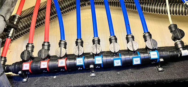 Day Off Yacht Photos Pics Water valve system in a 2015 Regal 53 Sport Coupe, featuring labeled red and blue pipes.