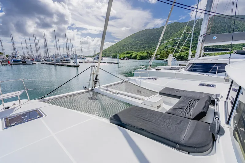As You Wish Yacht Photos Pics 2020 Lagoon 46 catamaran with sun loungers, docked in a scenic marina.