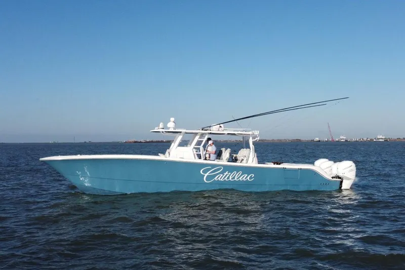 Catallac Yacht Photos Pics 2023 Invincible 46 Catamaran on open water, blue hull, clear sky.